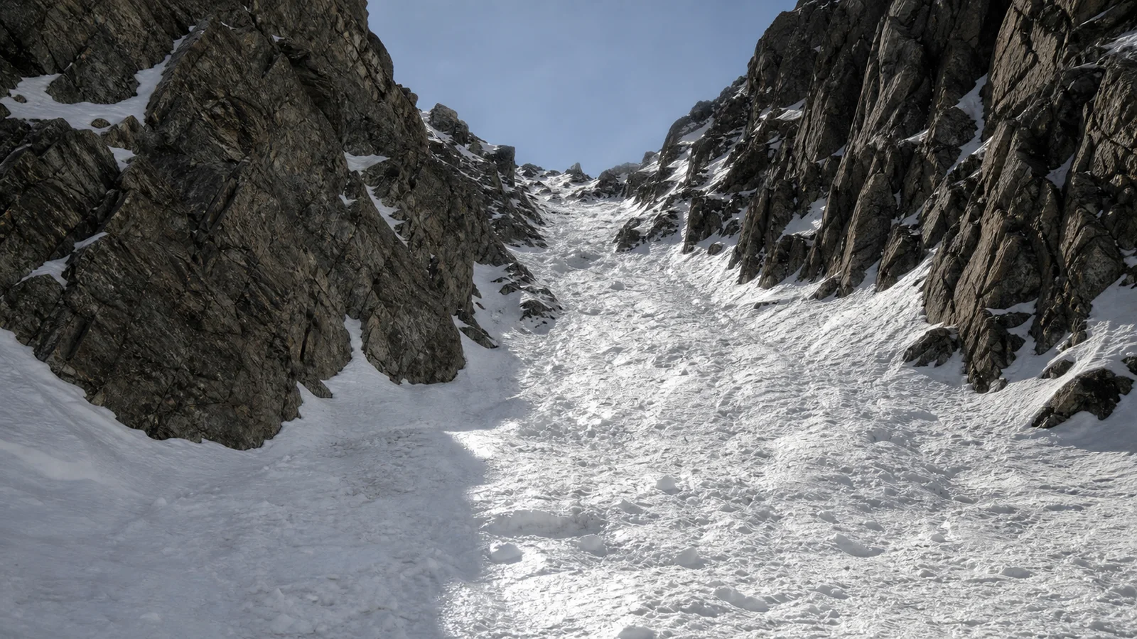 A steep alpine couloir filled with spring snow flanked by rocky walls in the Colorado Rocky Mountains